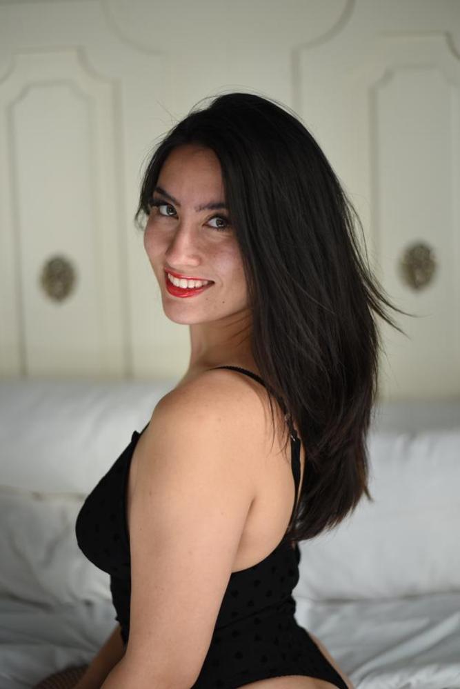 SE Asian model Kylie in a black leotard and fishnet stockings on the bed - SFW     