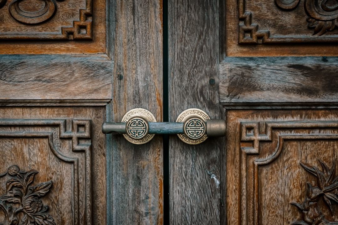A close up of a door handle on a wooden door