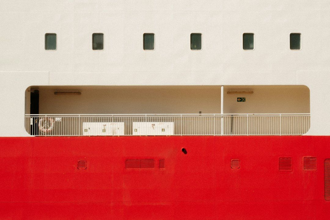 A white ship deck with a red hull and a metal railing