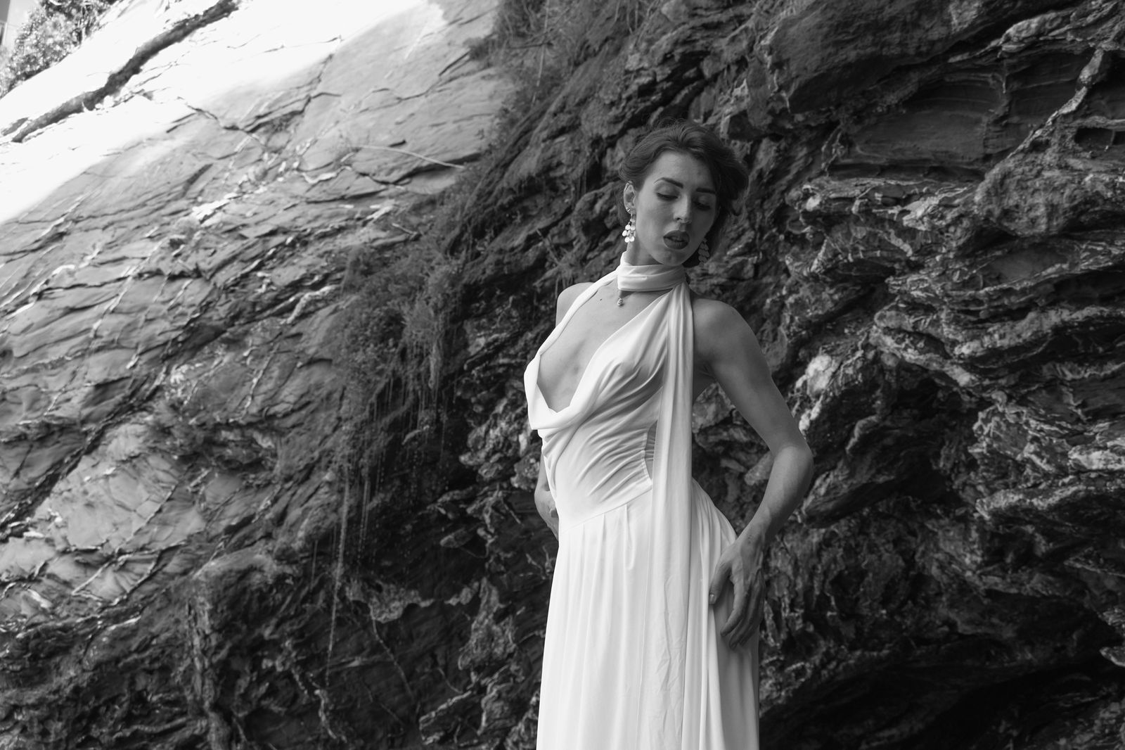 Nico dressed in white on sea rocks