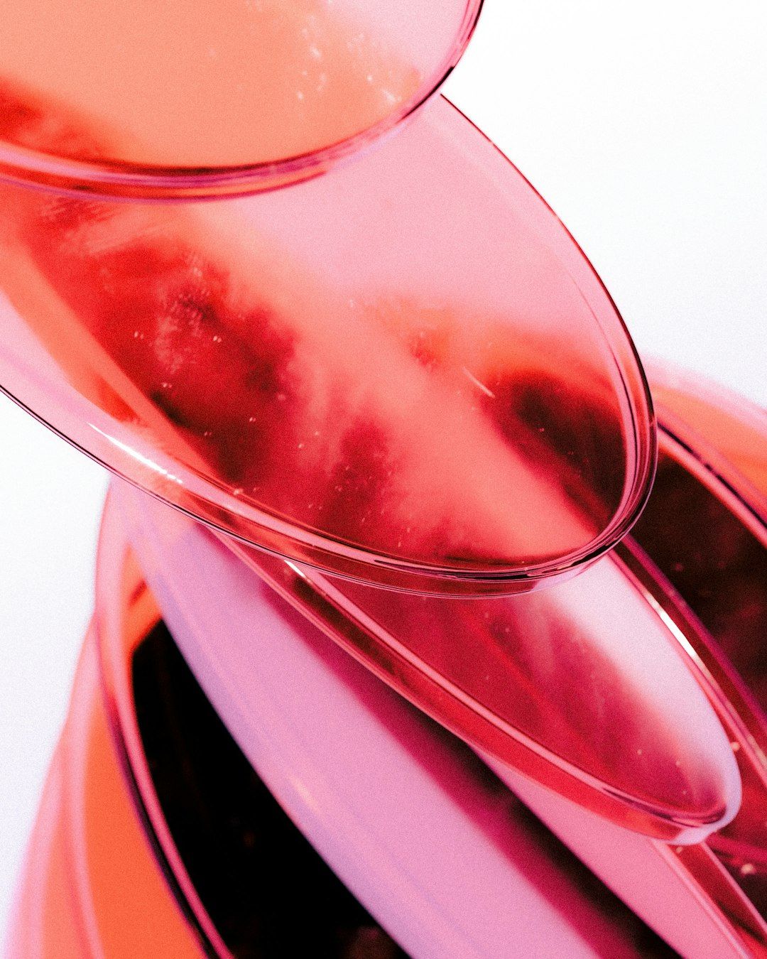 Stacked translucent pink plastic bowls creating overlapping circular shapes